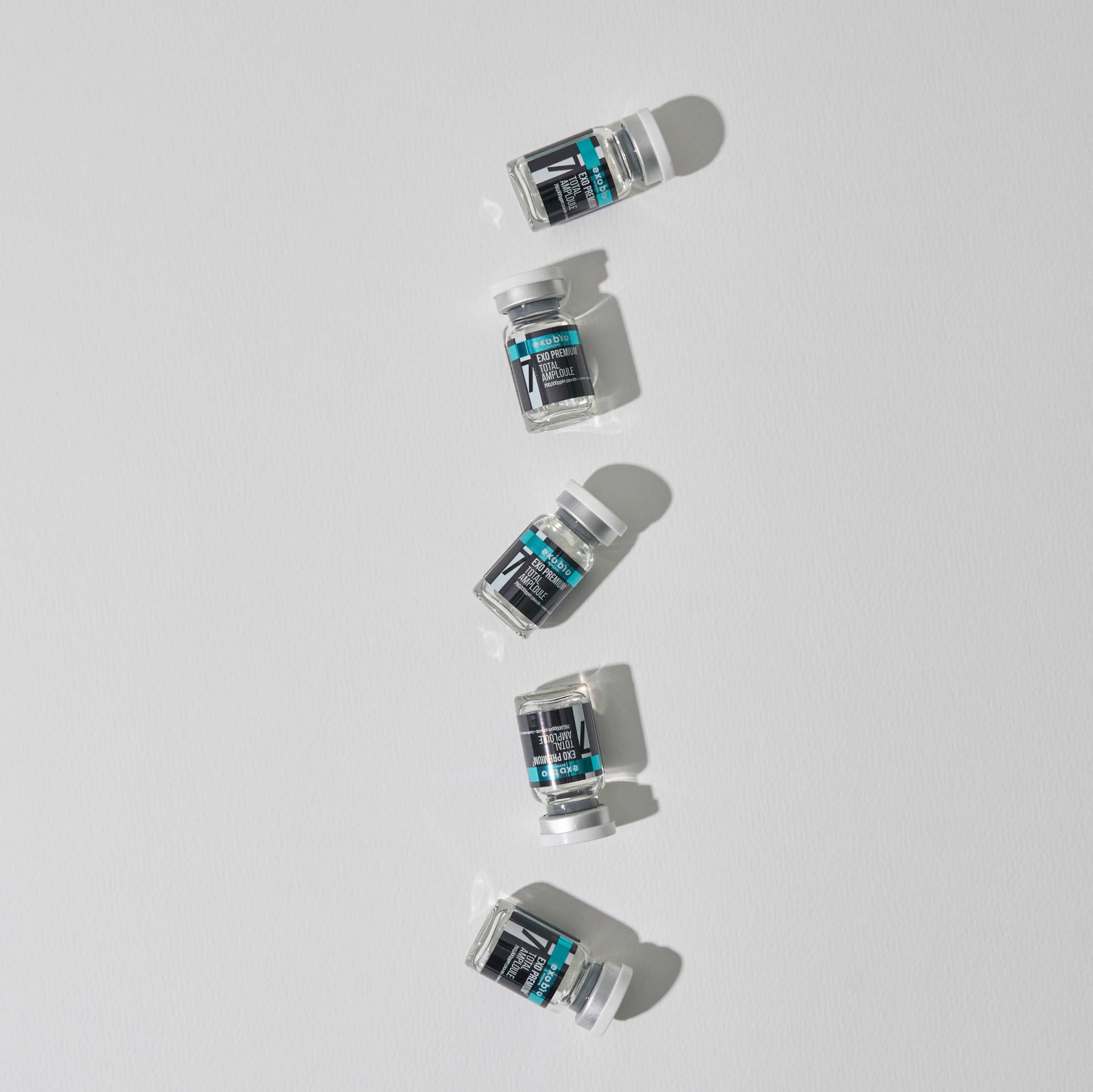 Fünf EXO Premium 7 Total Ampoule Fläschchen in einer Reihe auf hellem Untergrund
